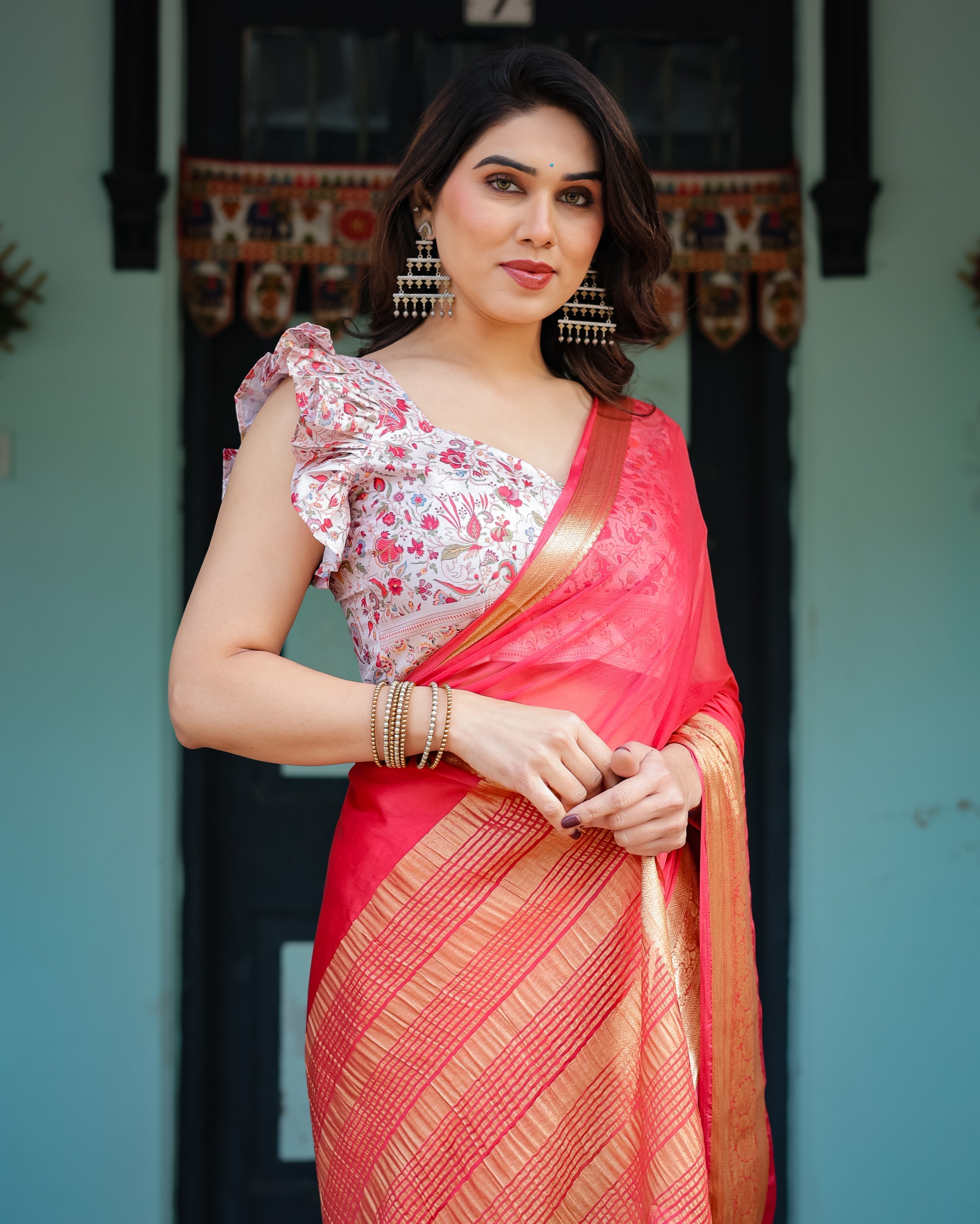Vibrant Coral Pink Plain Chiffon Saree with Gold Zari Border, Floral Ruffled Blouse & Tassel Detailing